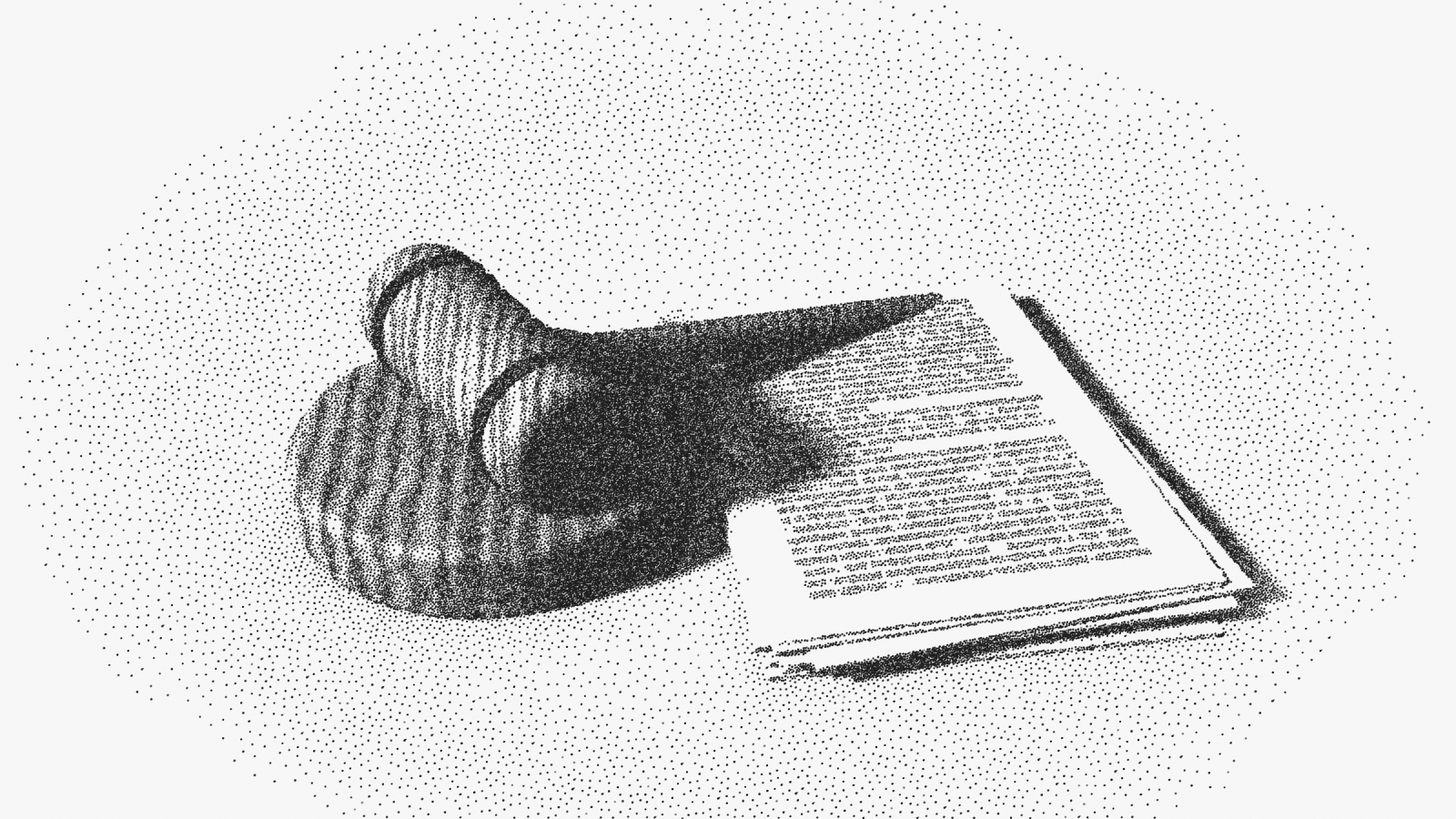 A wooden judge's gavel resting on its sound block, beside a squared stack of documents.